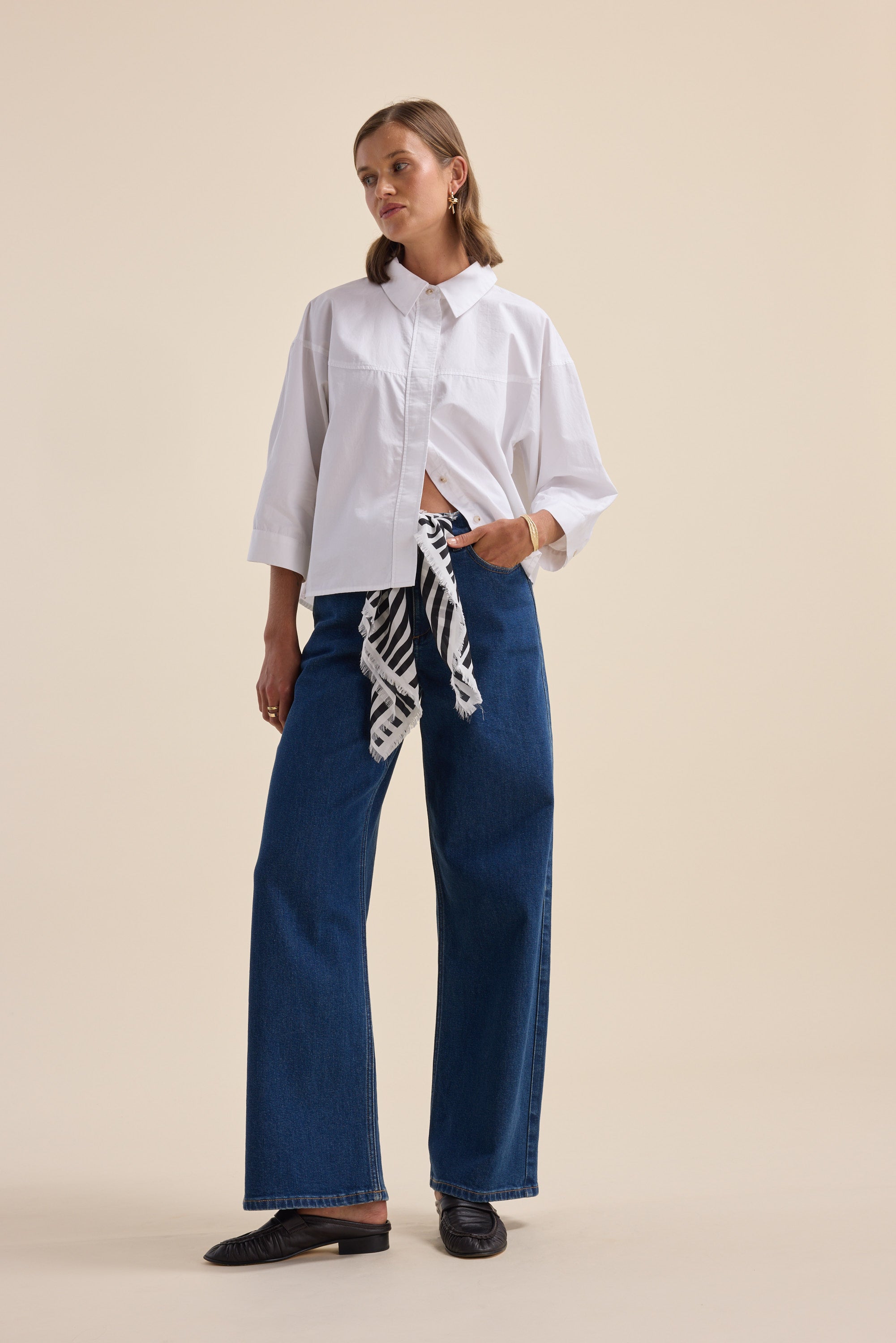 Woman in an Elementary Yoke Detail Shirt, wide-leg jeans, loafers, and striped scarf at waist.