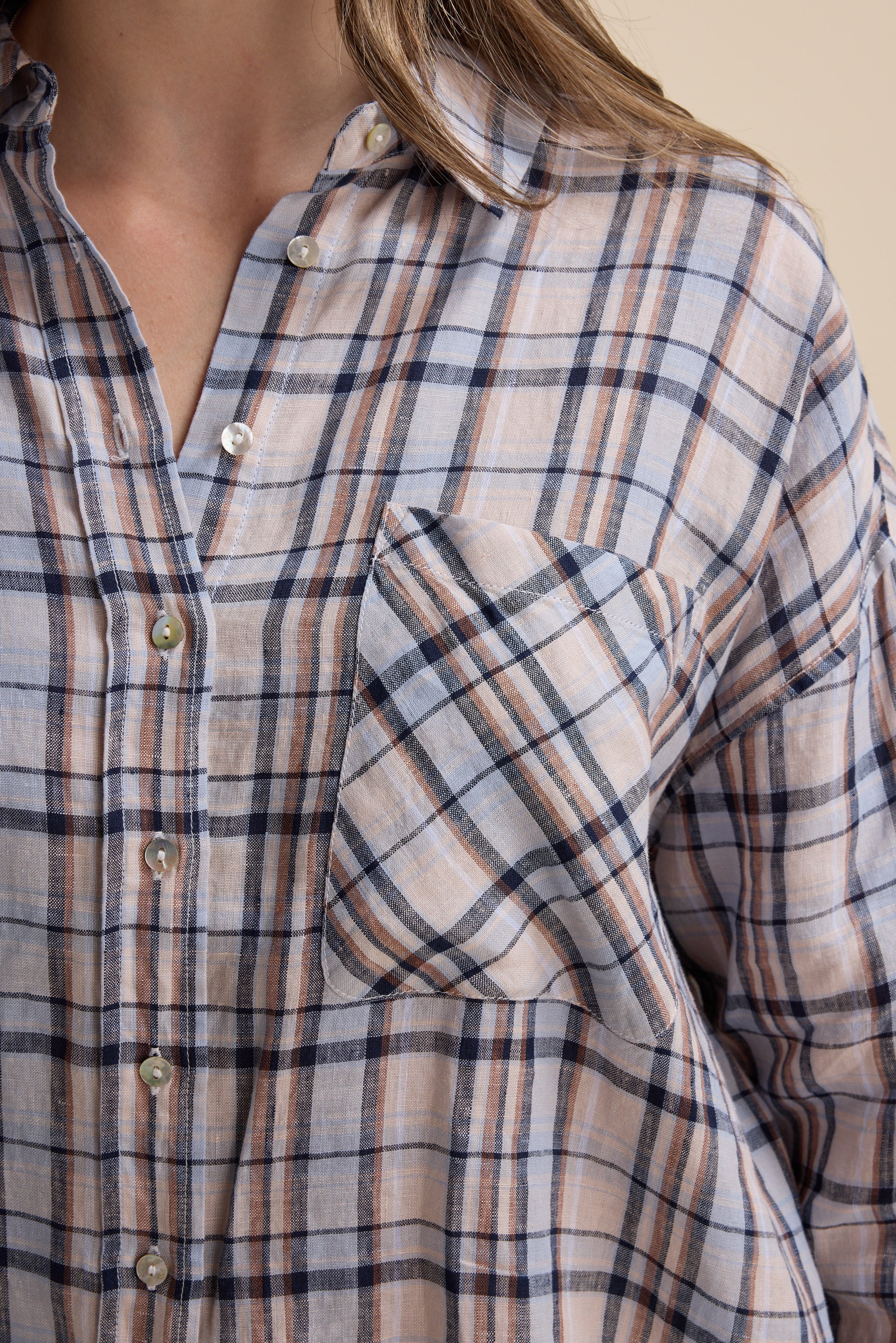 Close-up of a person wearing the Elementary Oversized Shirt by Elementary in blue and beige checks.