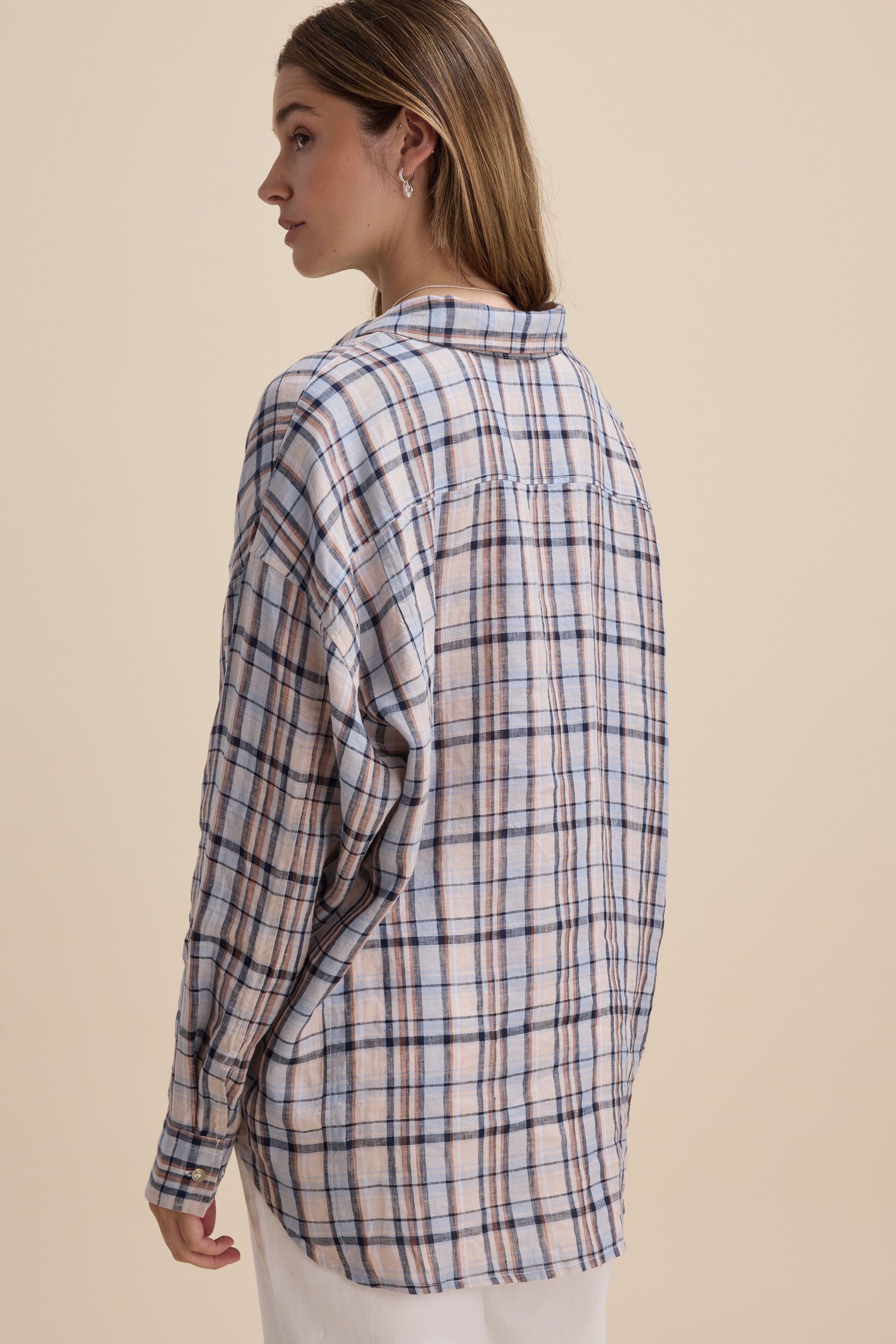 Woman in an Elementary Oversized Shirt faces away against a plain background.