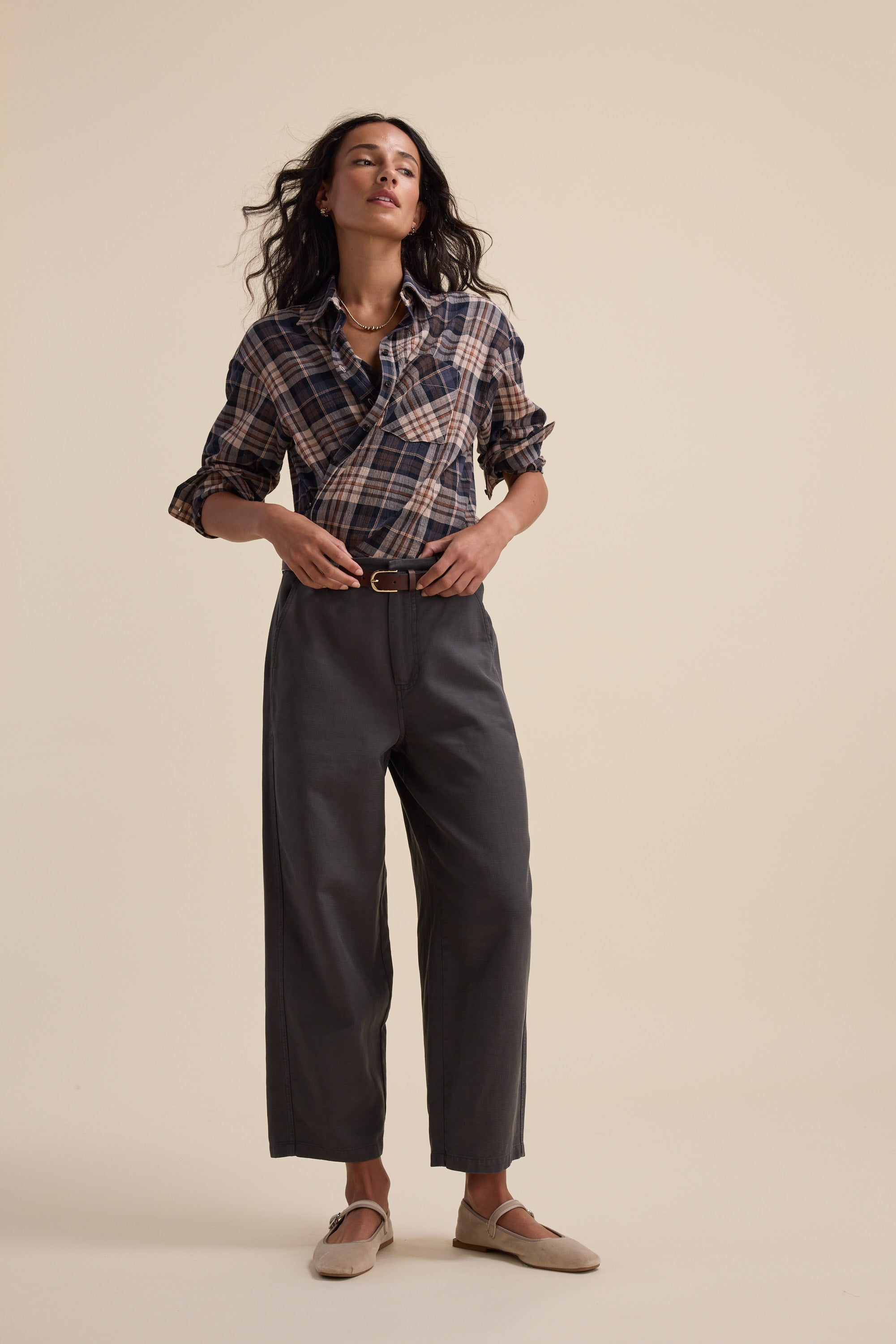 A woman wears Elementary Panelled Barrel Pants with hands on her belt.