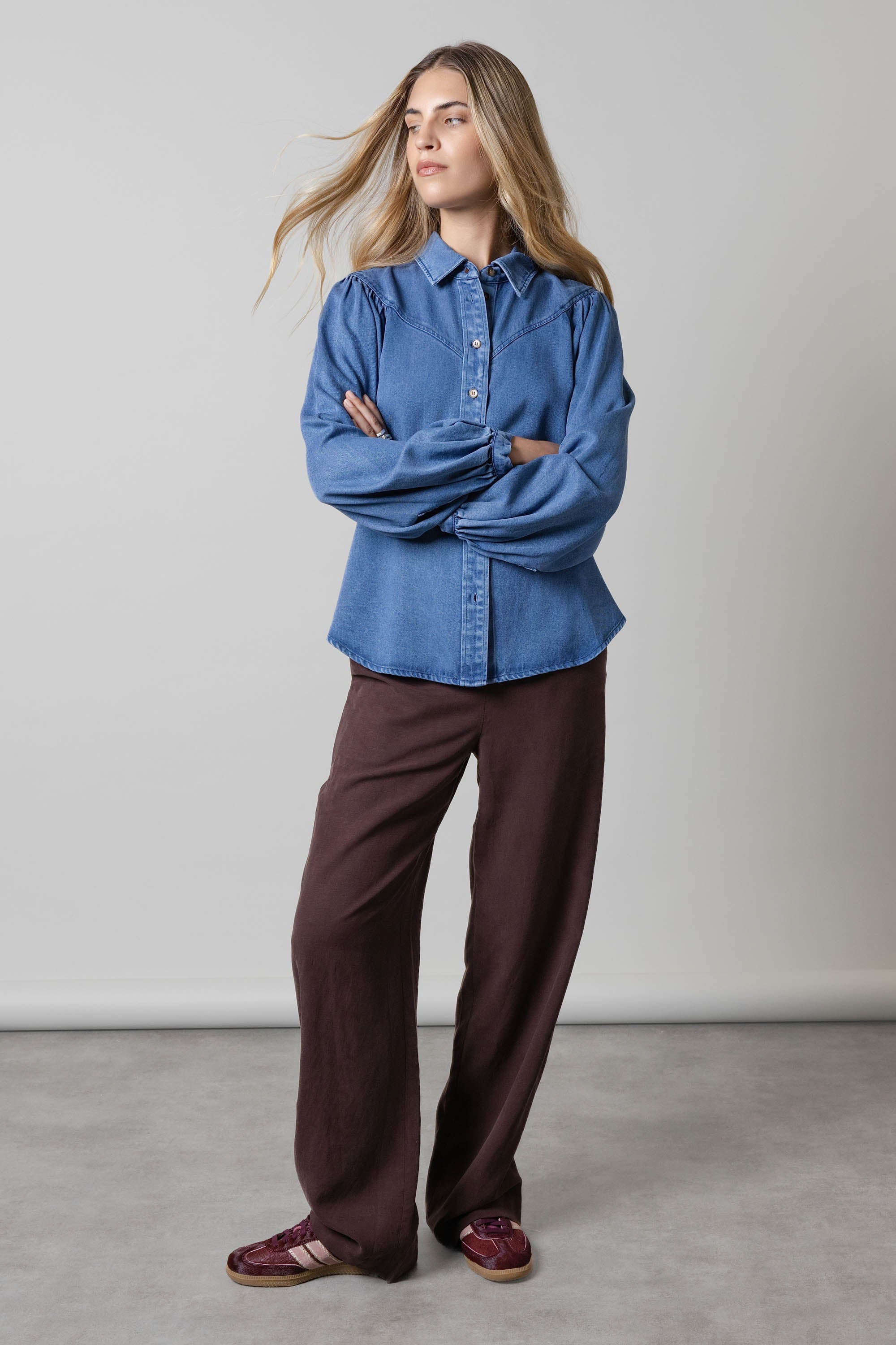 Woman wearing the Elementary Denim Shirt by Elementary, standing against a plain background.