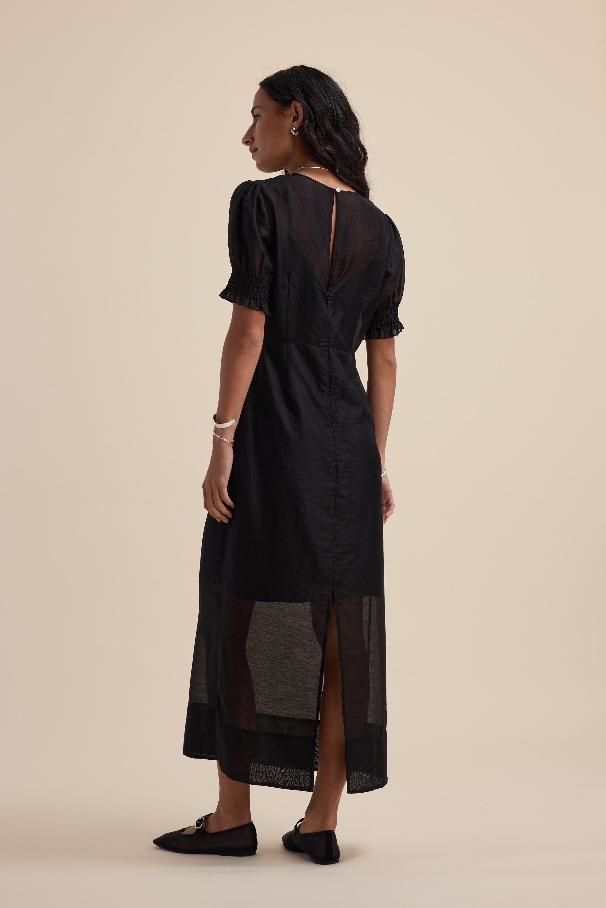 Woman wearing Max's The Sheer Layering Dress with black flats, facing away from the camera.