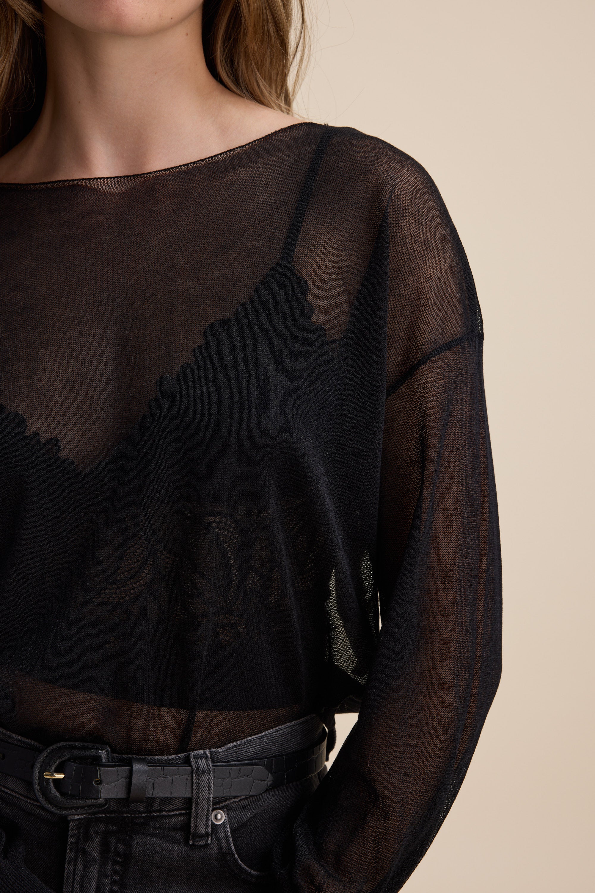 Max Addie Sheer Knitted Top layered over a black bralette and high-waisted black jeans.
