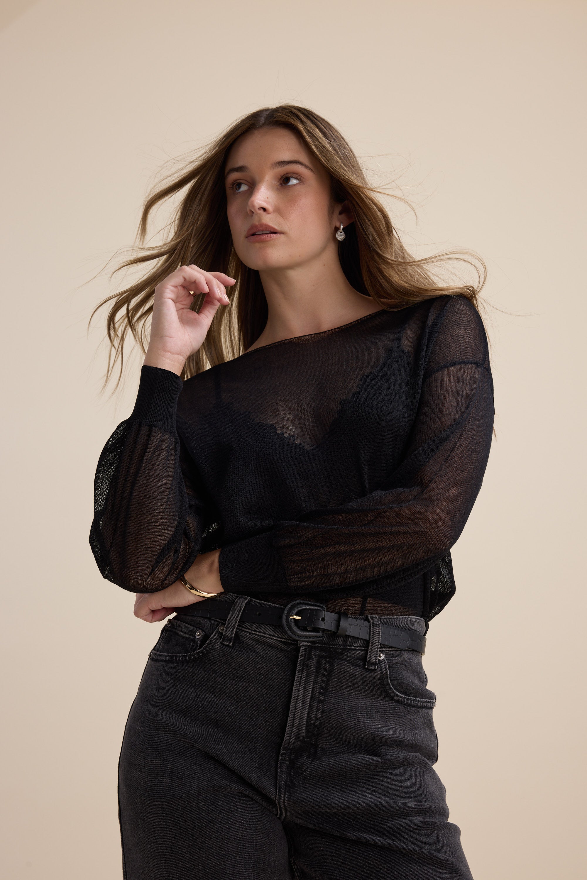 Model wears the Max Addie Sheer Knitted Top with black jeans against a beige background.