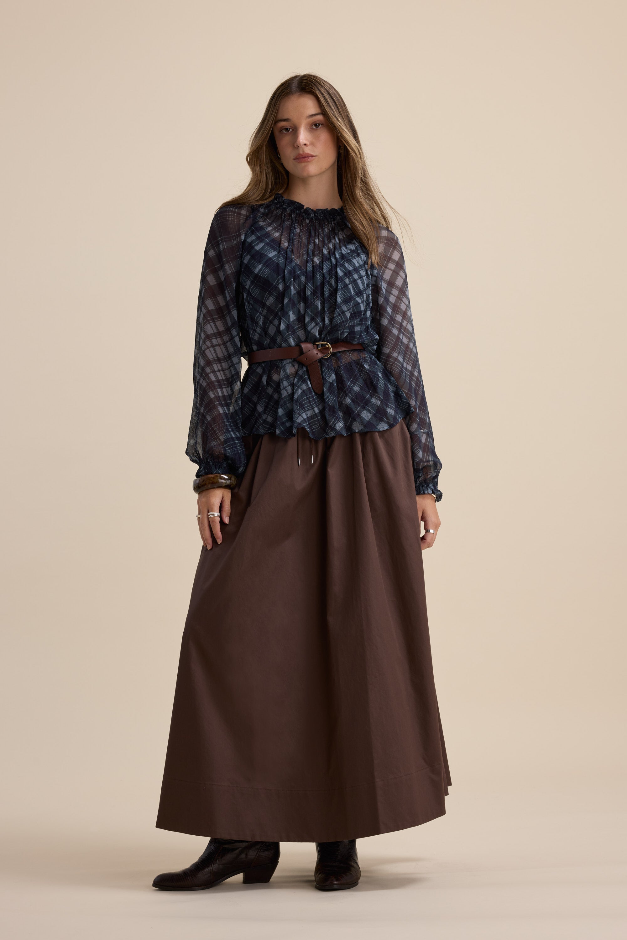 Woman in a Max Quinn Gather Detail Blouse, brown maxi skirt, belt, and boots.