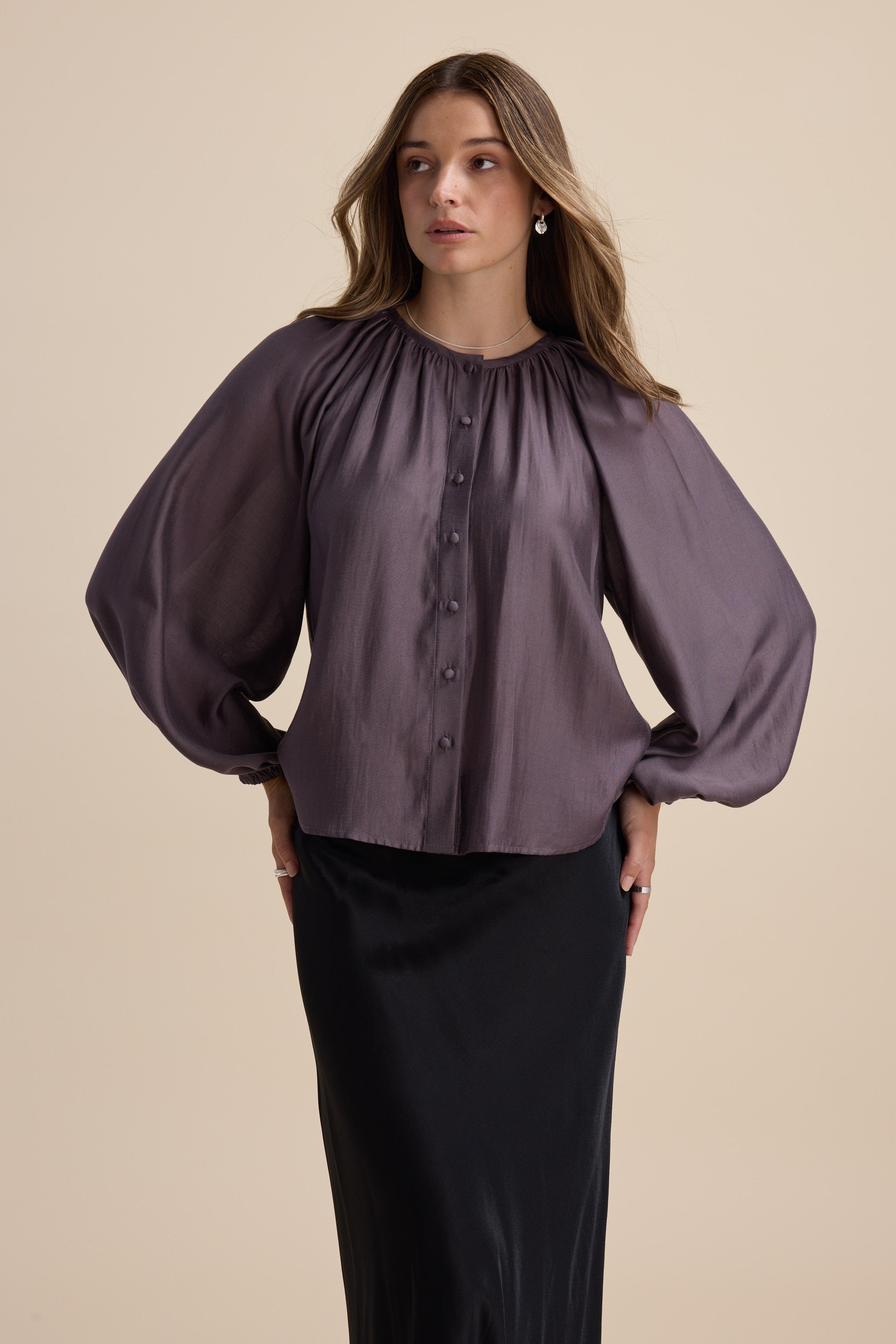 Woman wears Max Vivian Button Front Blouse in purple with blouson sleeves and a black skirt.