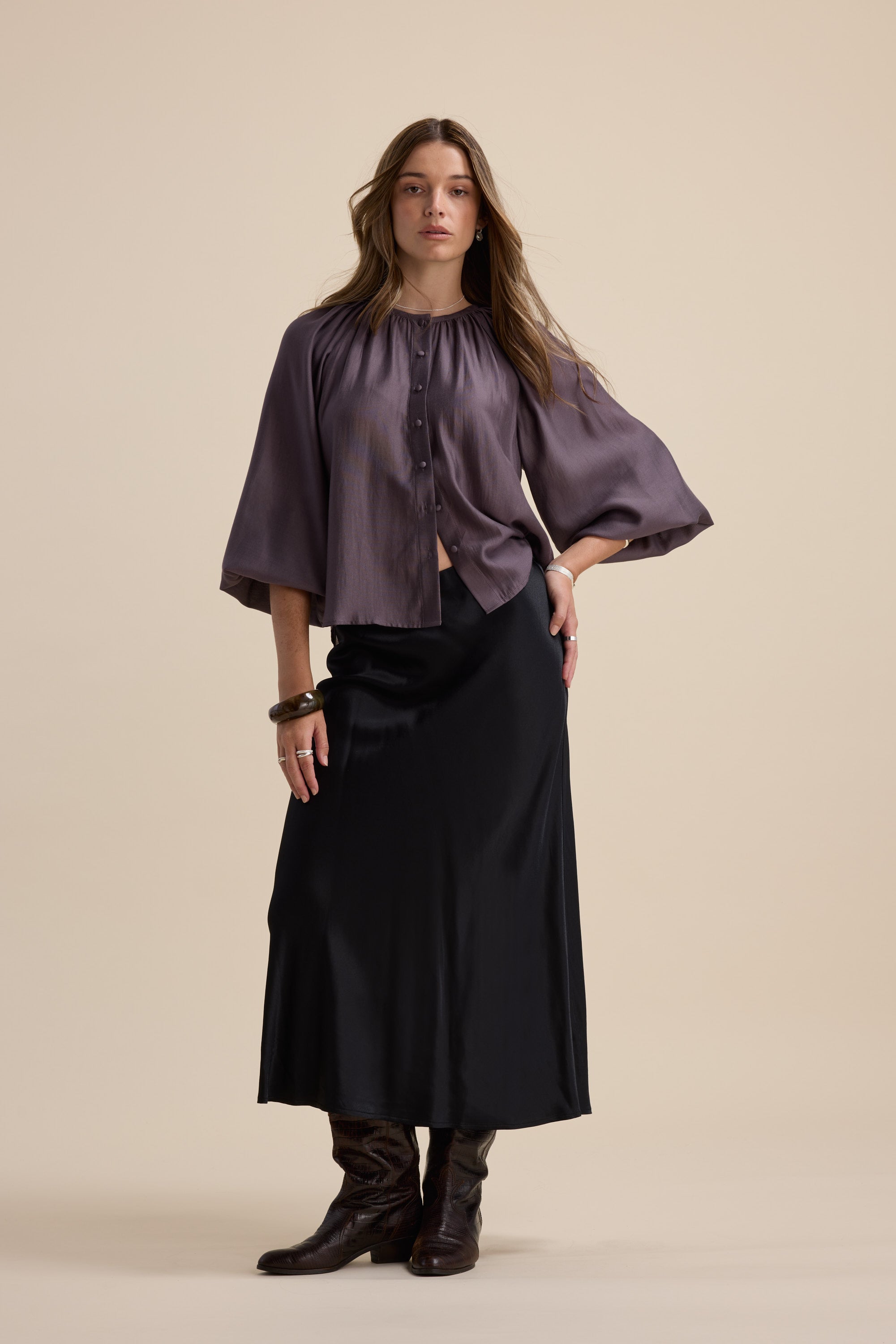 Woman in the Max Vivian Button Front Blouse poses against a beige background.