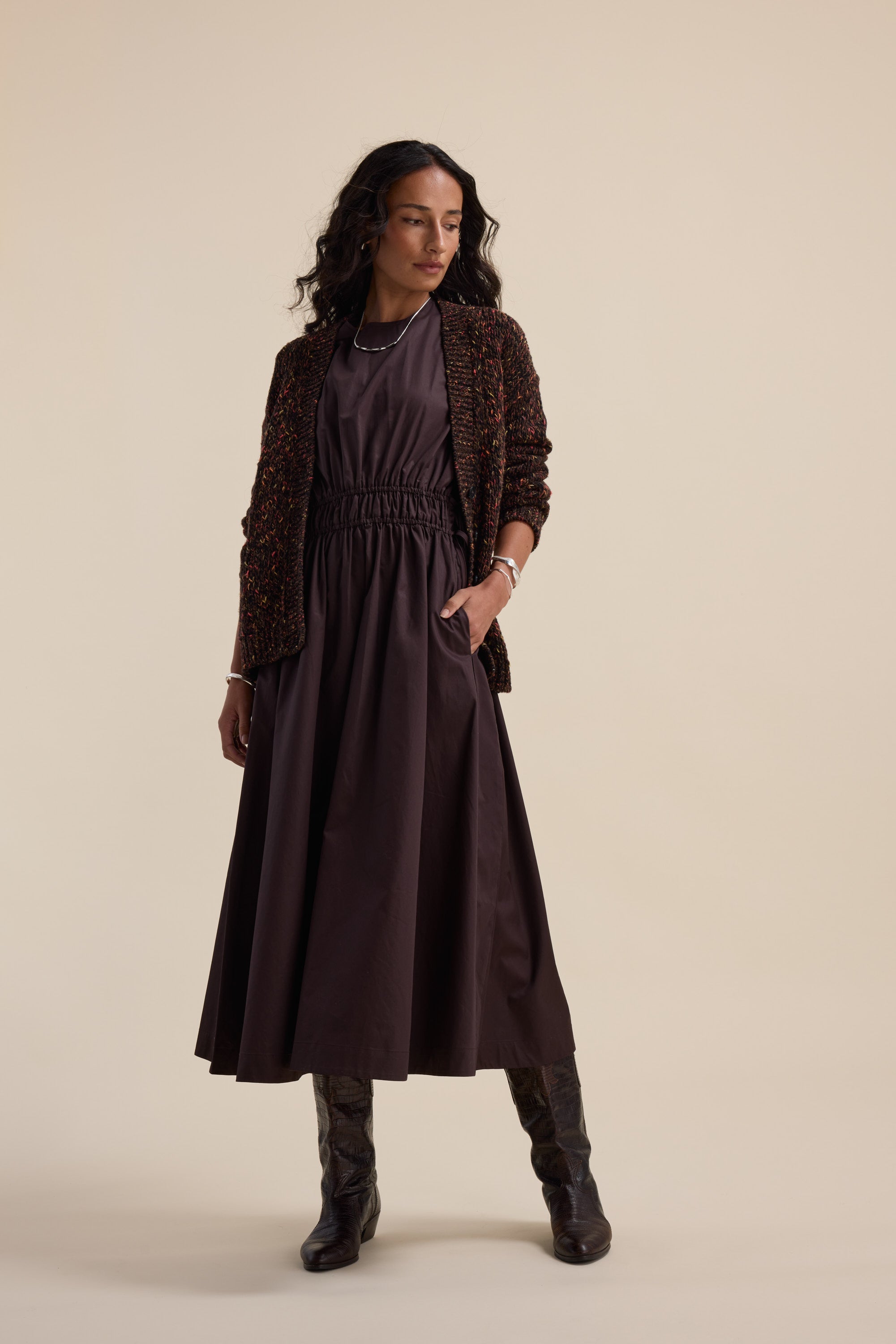 Woman in a Megan Tie Waist Dress by Max, textured blazer, and boots against a plain background.