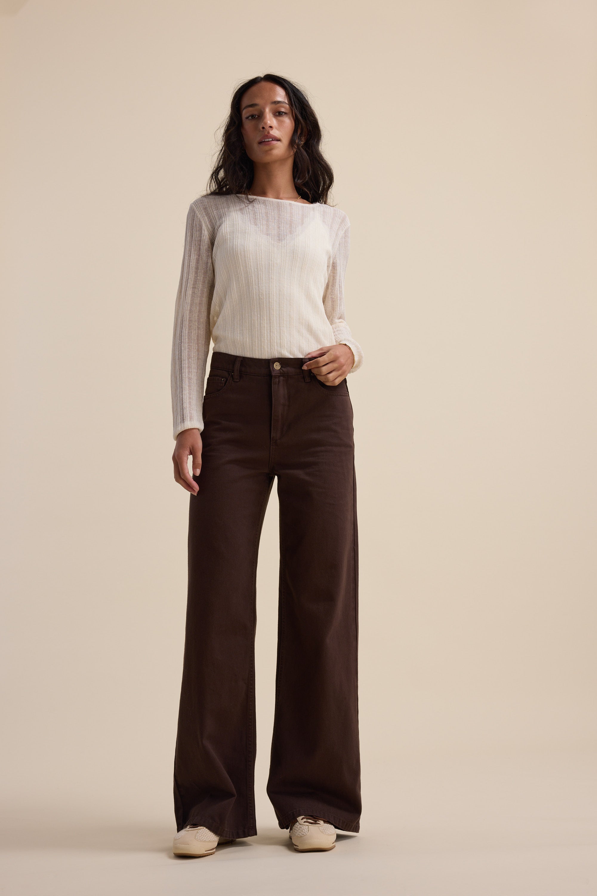 Woman in a white top and Max Alaska Wide Leg Jeans stands against a beige background.