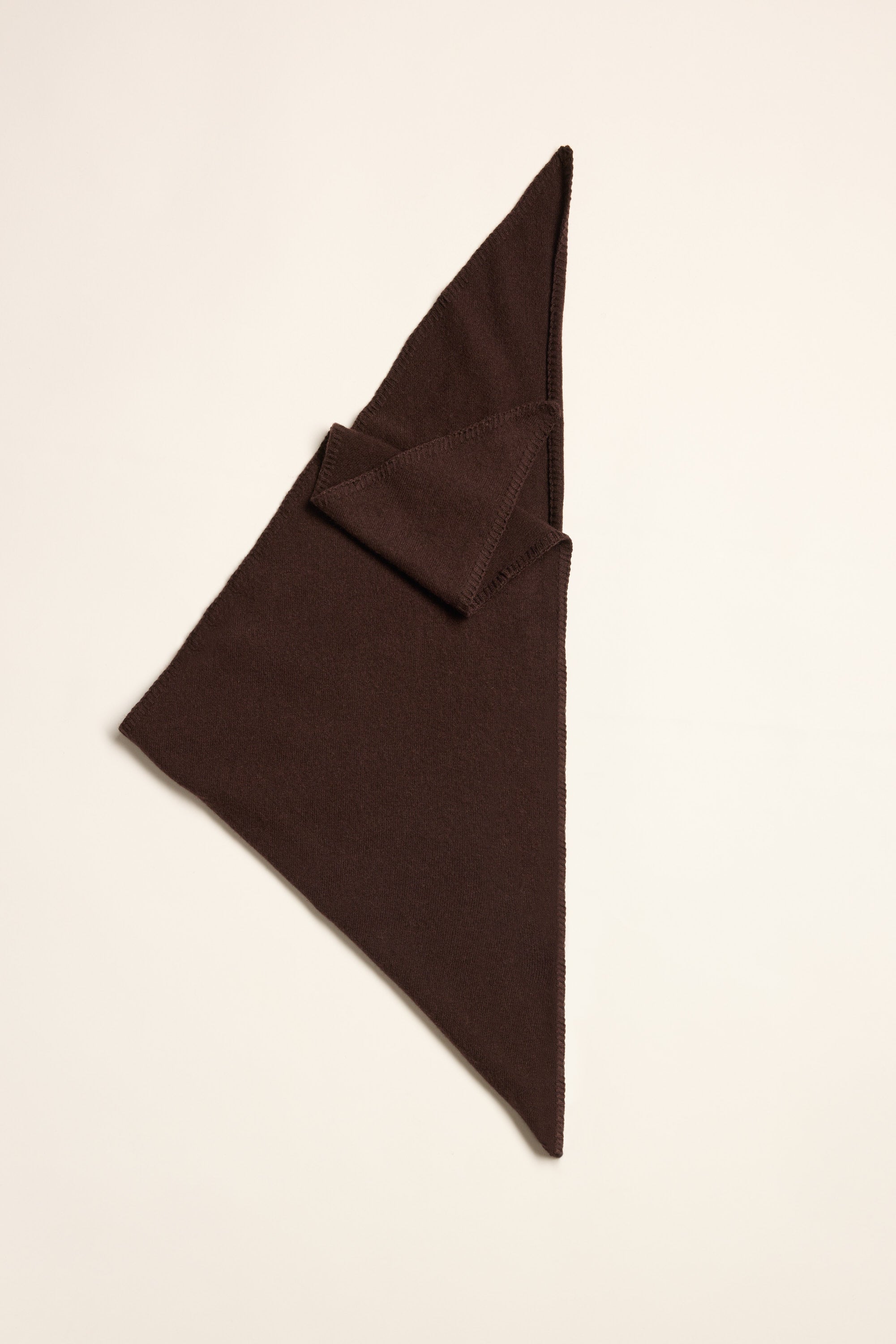 The Max Dagmar Cashmere Blend Triangle Scarf adds lightweight warmth on a light surface.