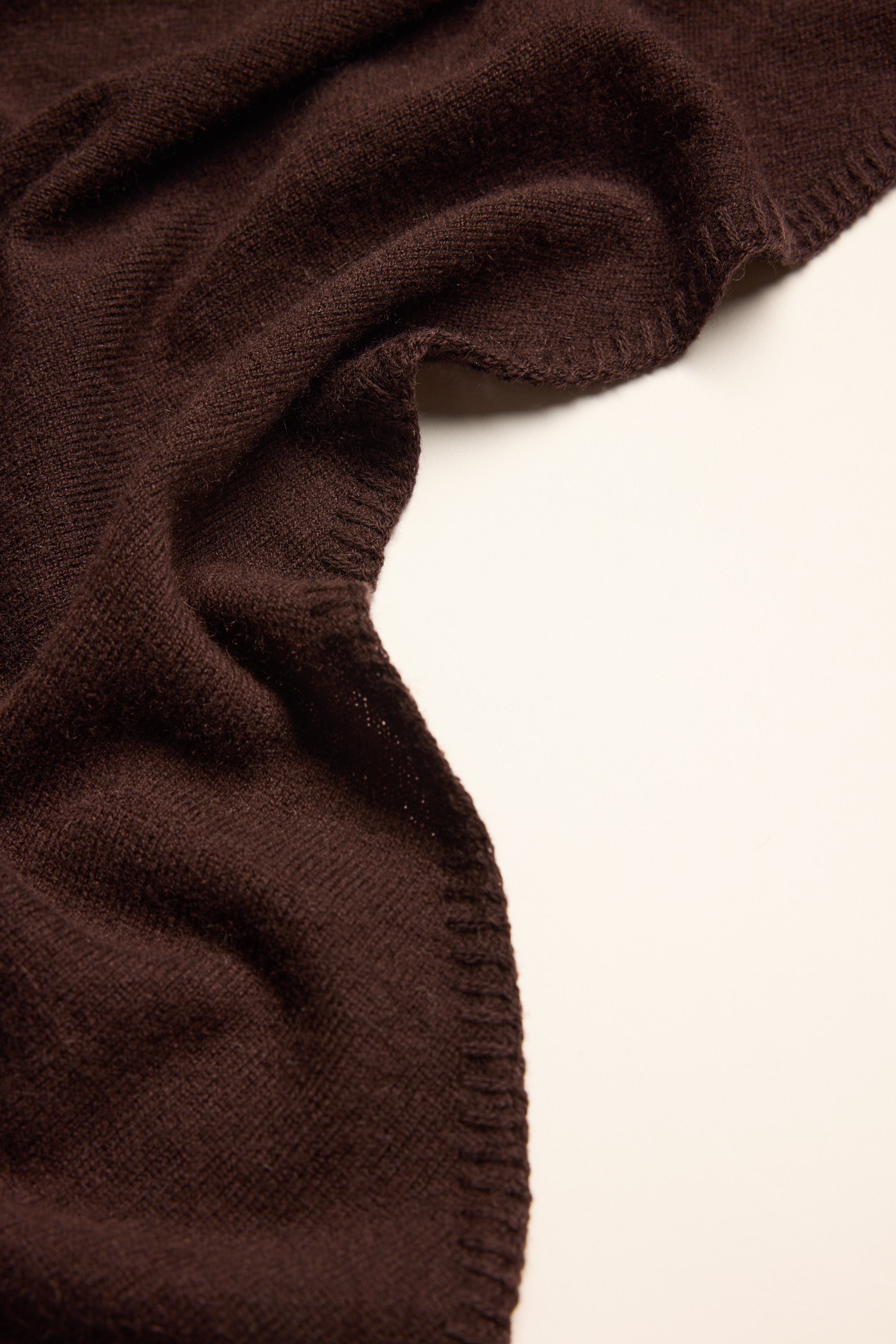 A close-up of the Dagmar Cashmere Blend Triangle Scarf by Max on a white surface.