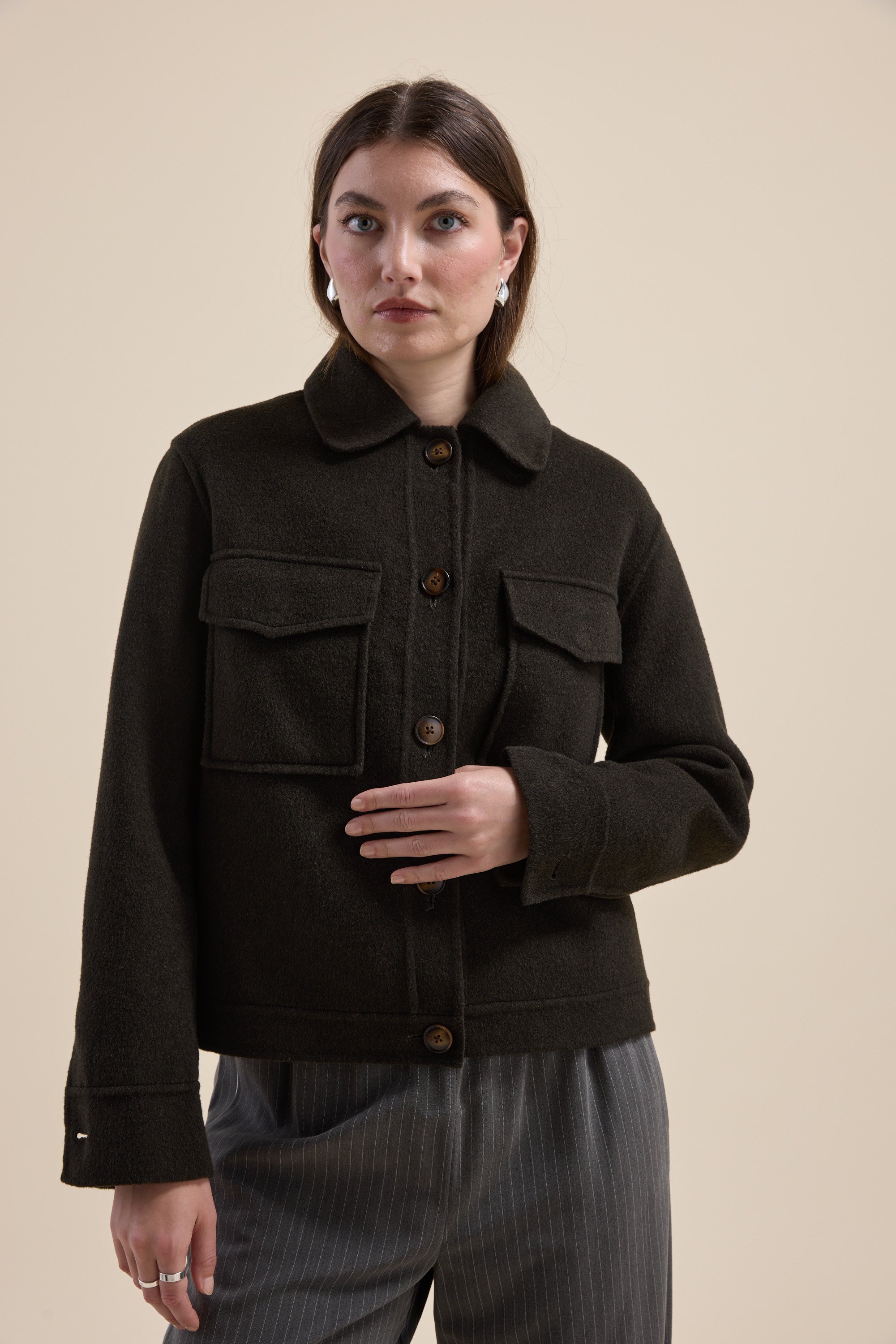 Woman in Max Kaia Wool Blend Cropped Coat and pinstripe pants, against a beige background.