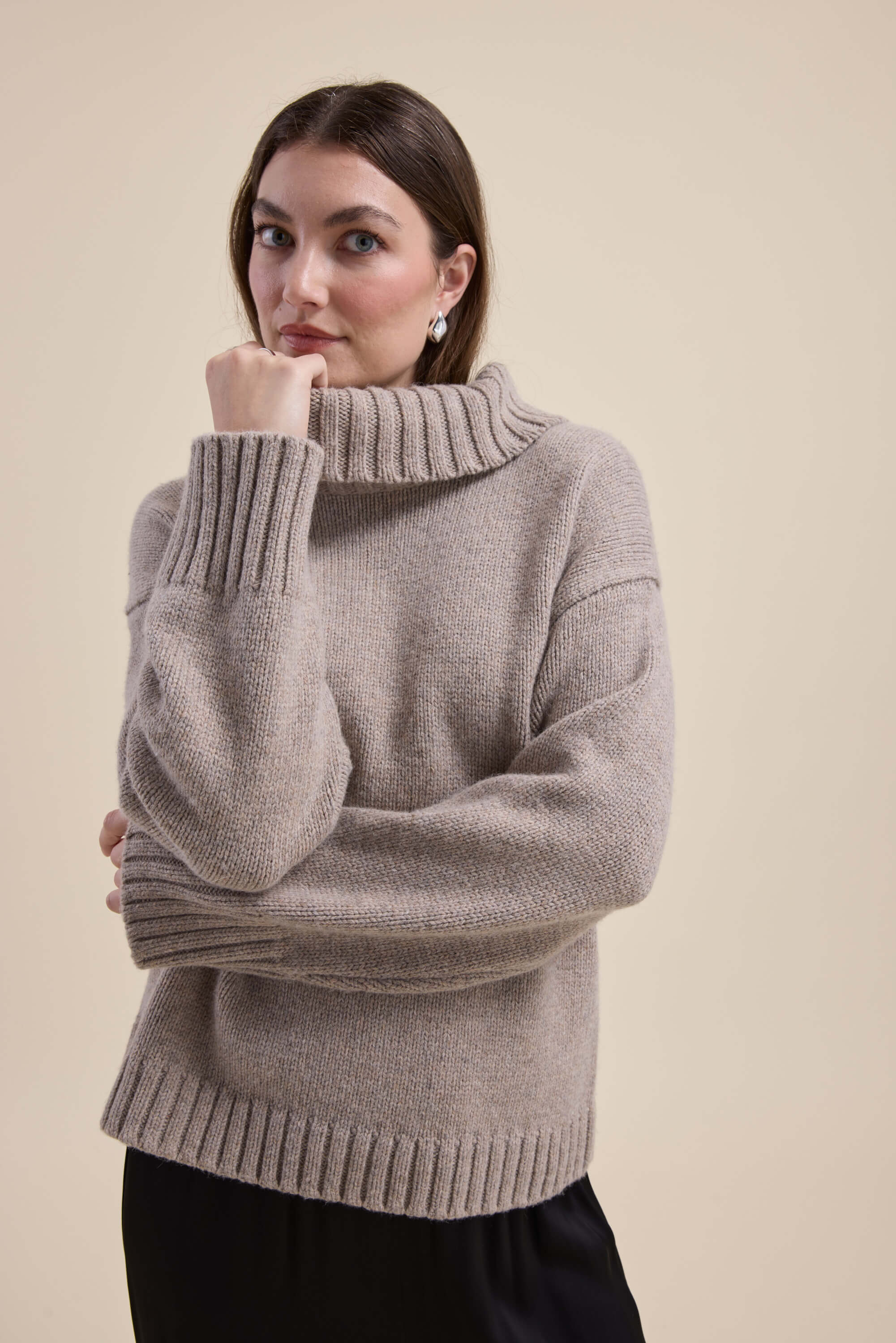 Woman in Max's Holly Wool Blend Roll Neck Sweater, hand on chin, looking at camera.
