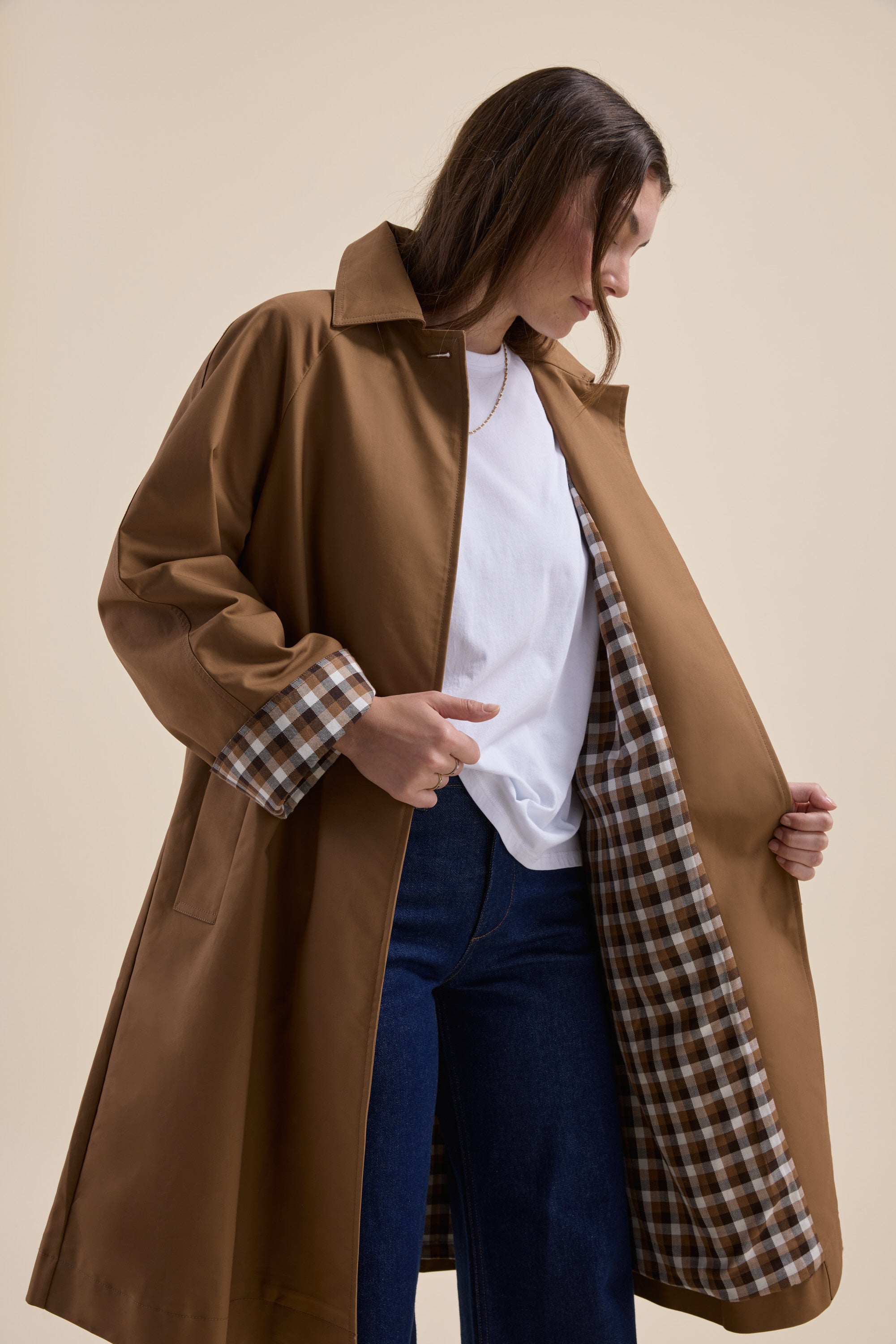 Woman in Max London Trench Coat with plaid lining, white shirt, and jeans.