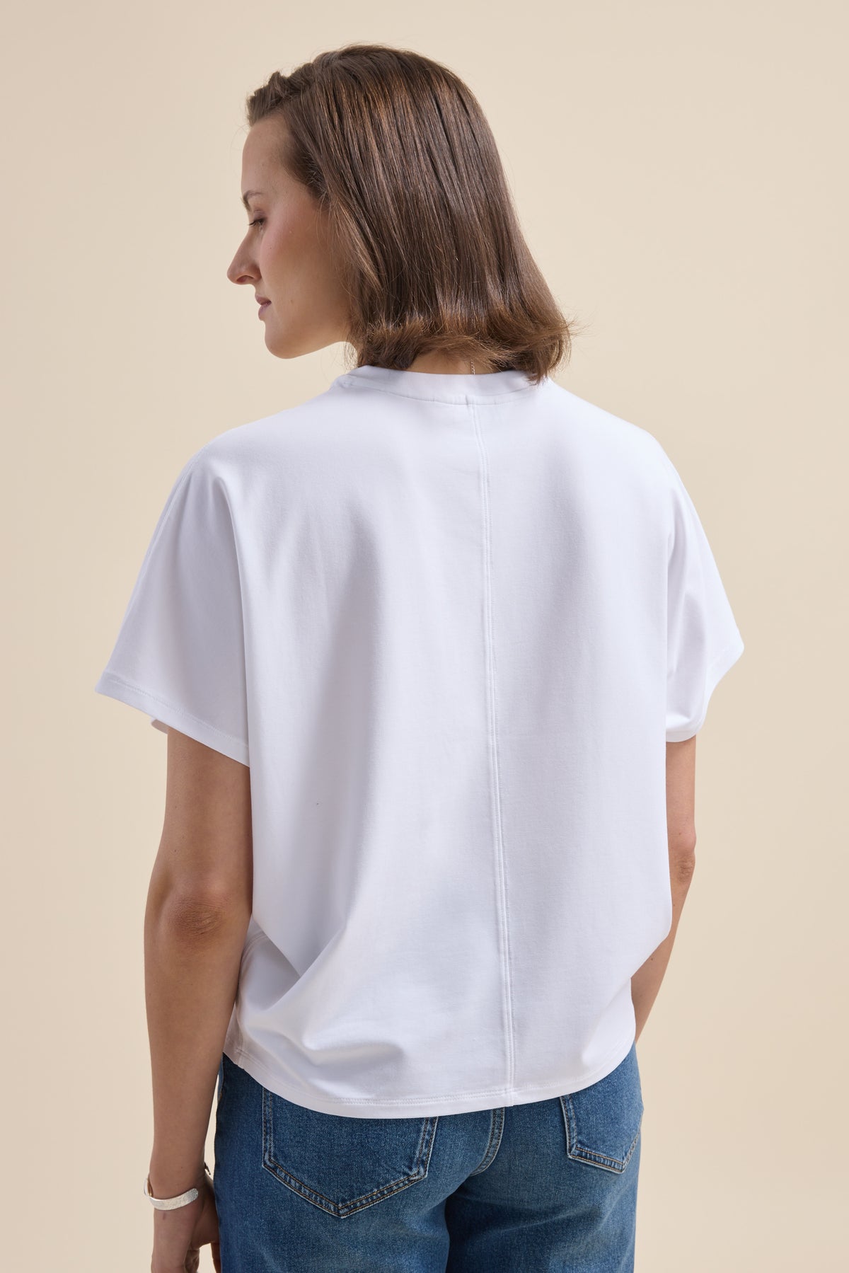 Person in Elementary Slouchy Short Sleeve Tee and blue jeans, viewed from the back.