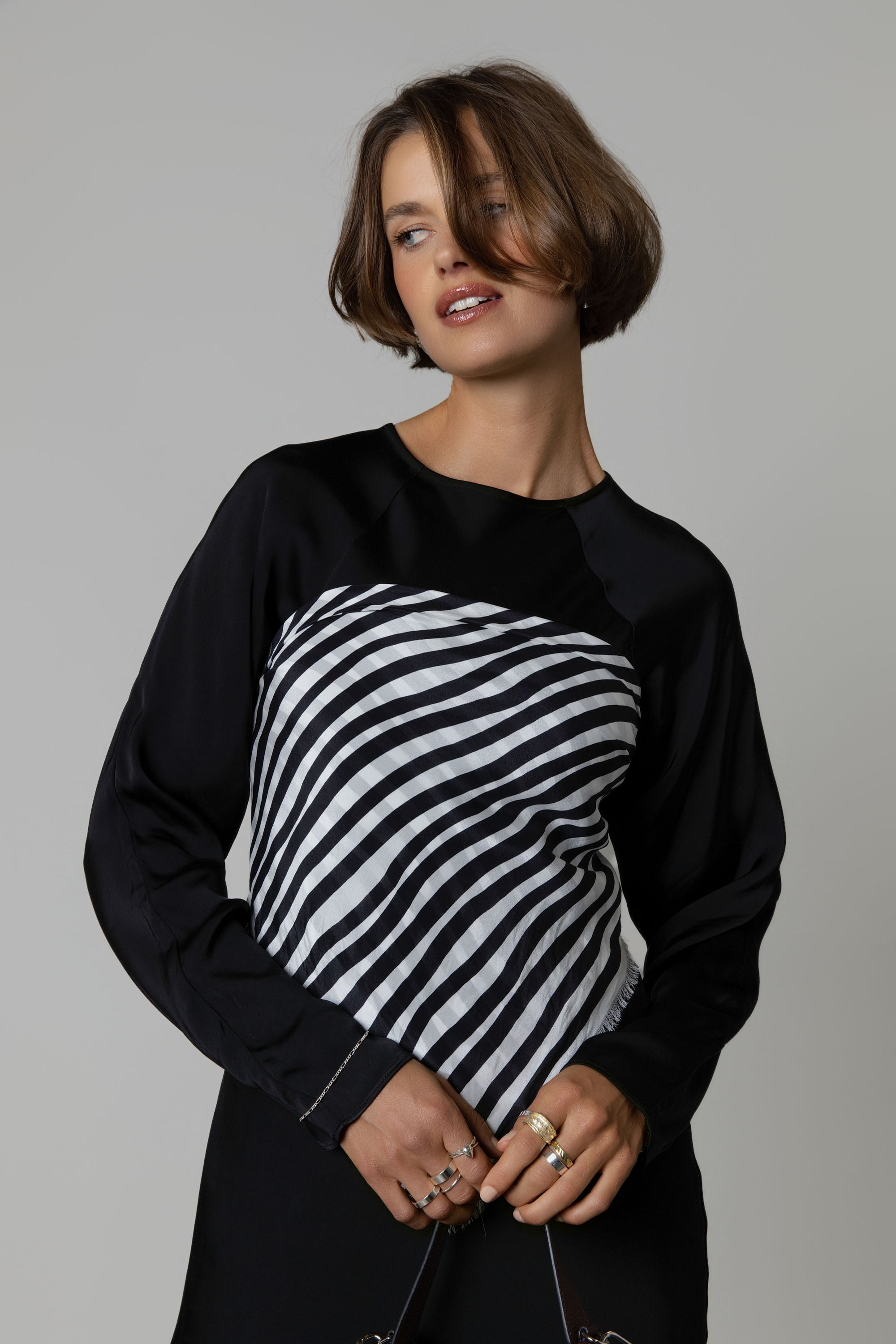 Woman in a black dress, styled with the Max Mable Frayed Edge Silk Scarf for versatile looks.
