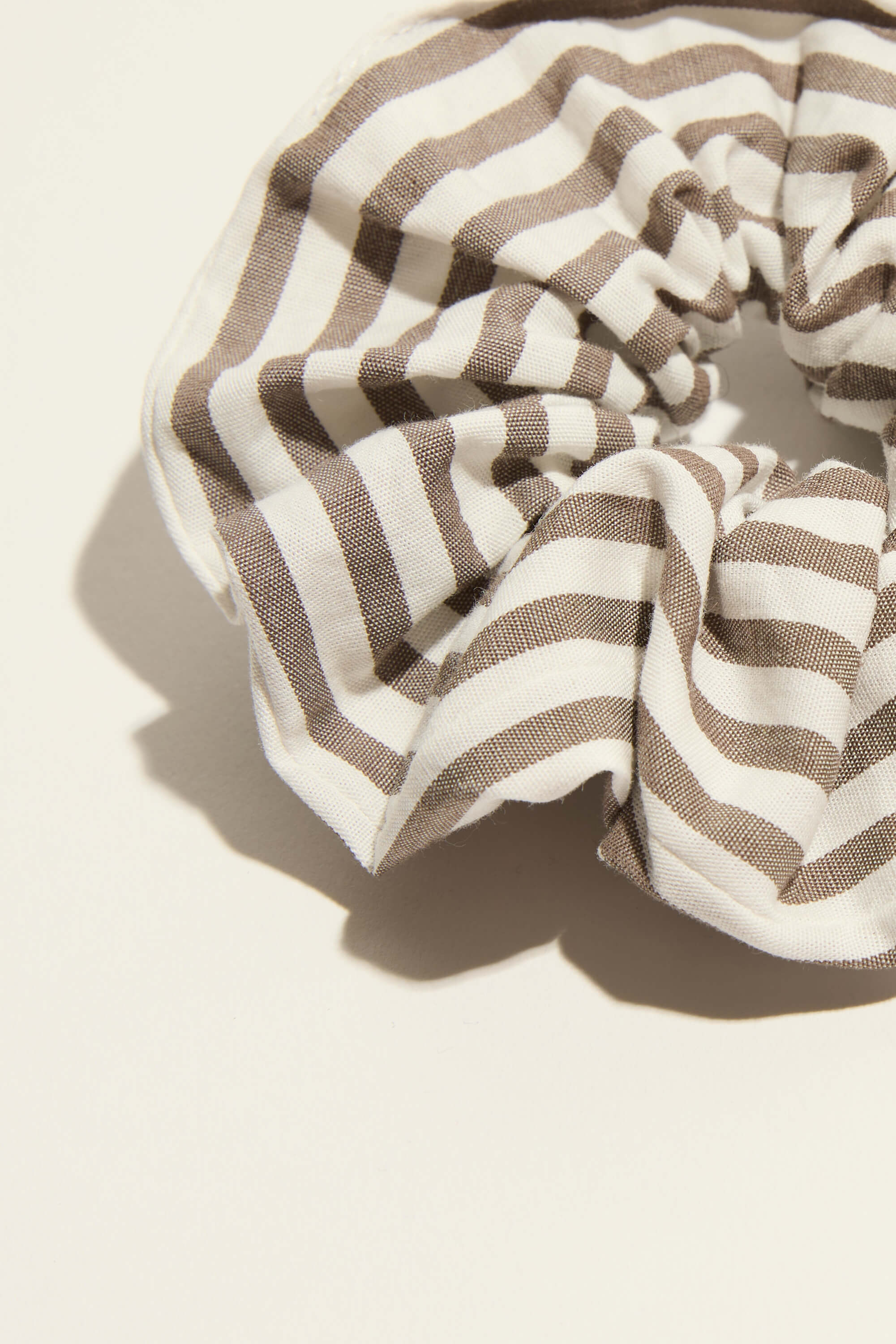 The Max Sadie Organic Cotton Scrunchie features brown and white stripes on lightweight fabric.