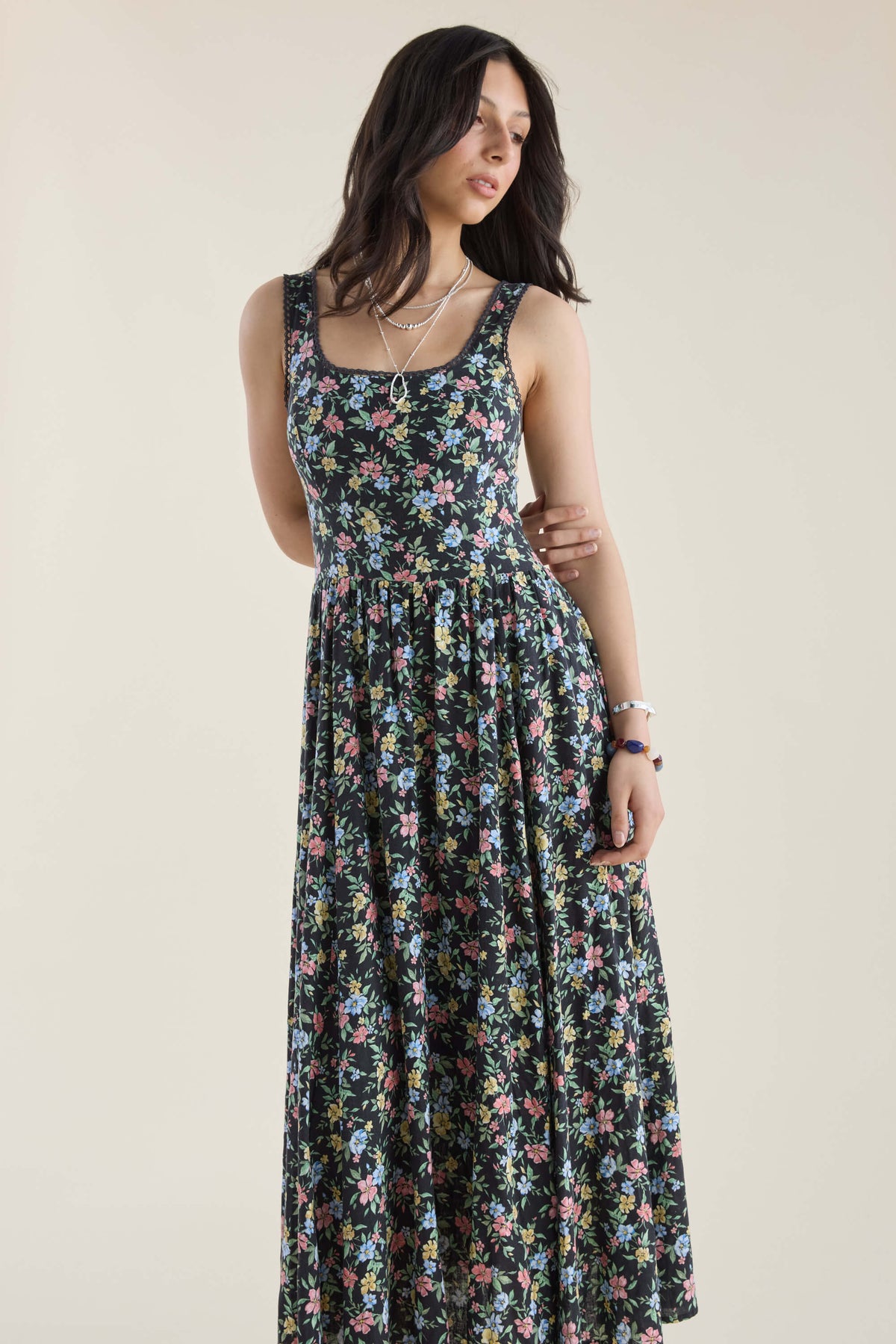 Woman in Max Aria Gathered Waist Midi Dress, sleeveless, looking sideways against plain backdrop.