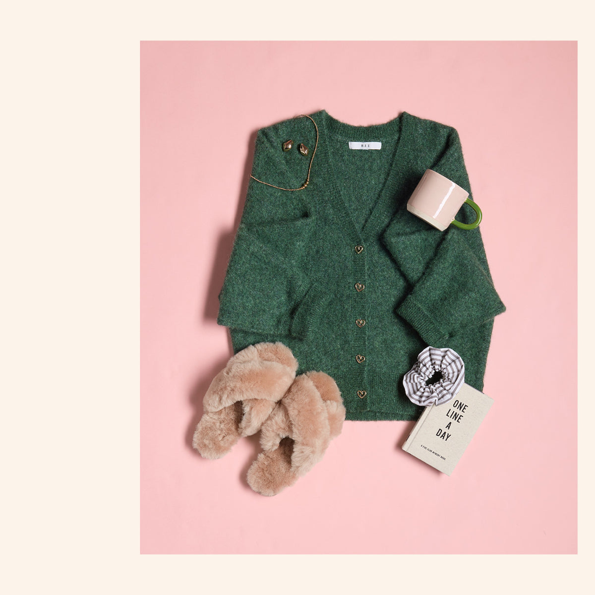 Cozy green cardigan outfit with slippers, mug, jewelry, and NZ-inspired journal.