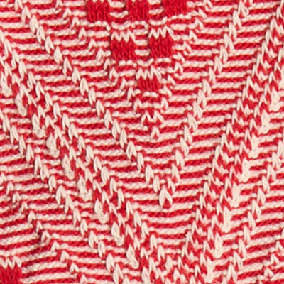 Close-up of NZ red and white knitted fabric with a chevron pattern.