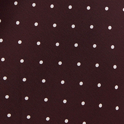 White polka dots on a dark brown NZ-inspired background.