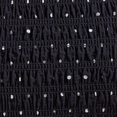 Close-up of black ruched fabric with NZ-inspired white polka dots in horizontal rows.