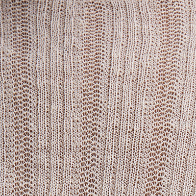 Close-up of NZ beige knitted fabric with a delicate lace-like pattern.